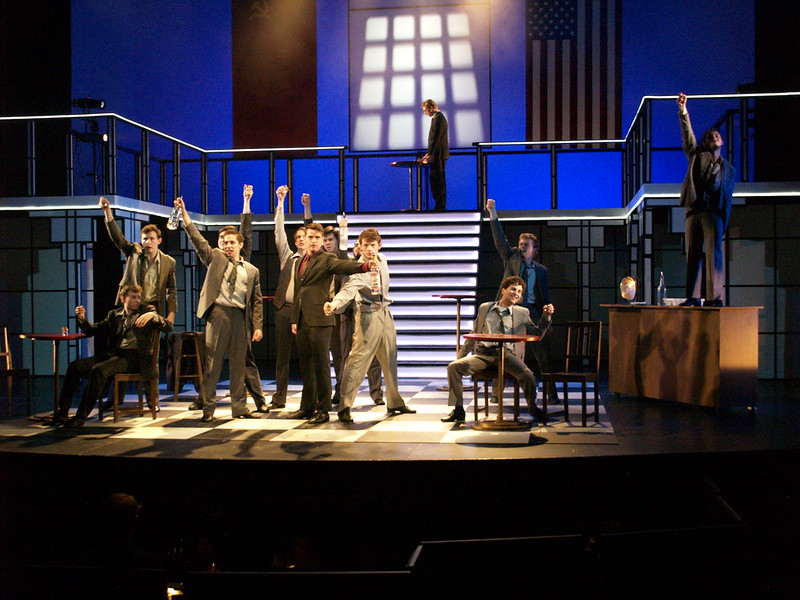 a group of men in suits acting on stage