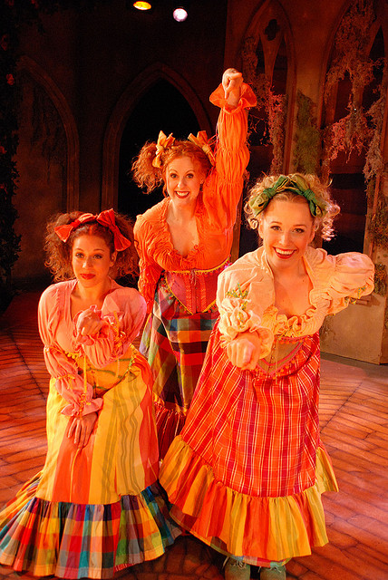 three actresses with curled hair in their costumes
