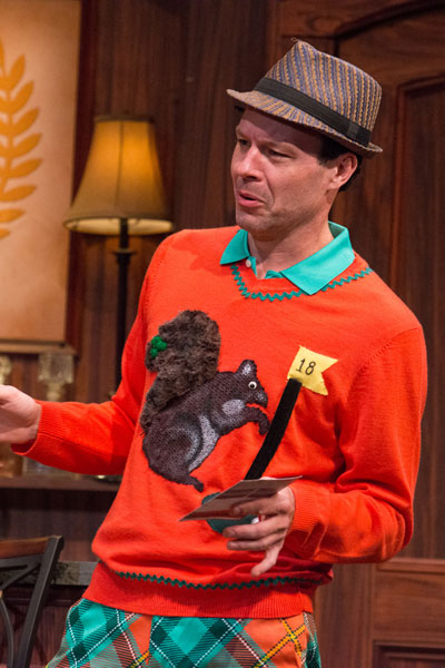 an actor wearing an orange sweater and a hat
