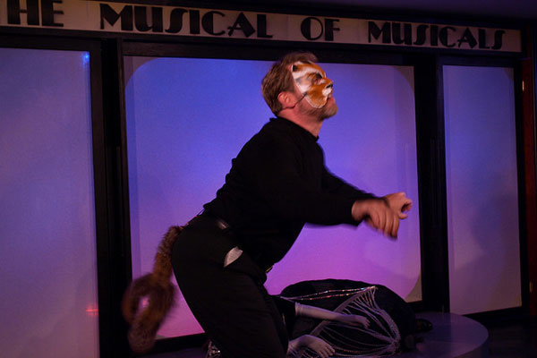an actor in black clothing with a mask on